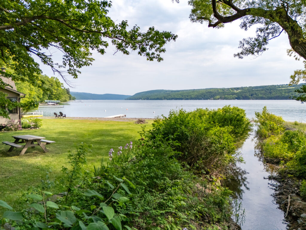 A view looking over the creek, which runs beside the lawn, to the lake.